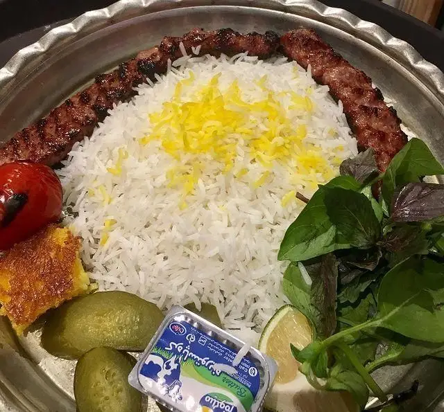 چلو کباب کوبیده اصیل و خوشمزه با برنج سفید و زعفرانی، ته دیگ طلایی، گوجه کبابی، سبزی تازه و کره در کافه رستوران دورهمی امامزاده حسن تهران