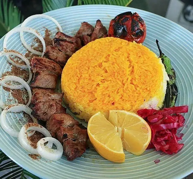 بشقاب دلپذیر کباب گوشت ایرانی با برنج زعفرانی، گوجه و فلفل کبابی، پیاز، لیمو و ترشی از کافه رستوران عمو سهراب