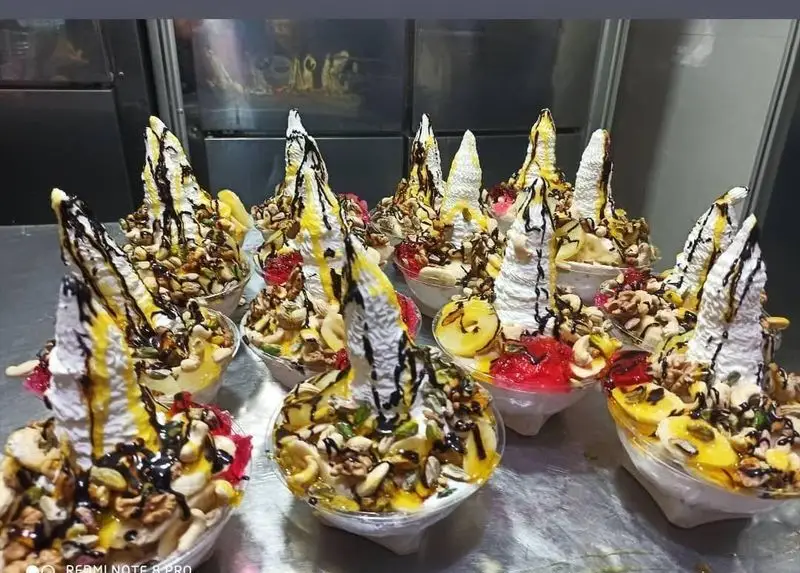 سرو بستنی‌های رنگارنگ و مغذی در آبمیوه بستنی بهار ترافیک شعبه ۱، با تزئینات خاص آجیل، میوه‌جات و سس‌های شکلاتی و طلایی.