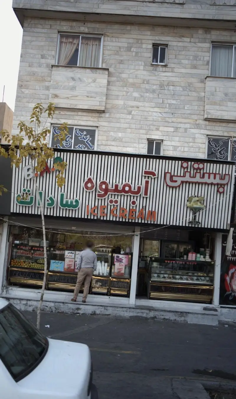 نمای کامل فروشگاه بستنی و آبمیوه سادات، با ویترین‌های پر از میوه‌های تازه، بستنی‌های متنوع و آبمیوه‌های طبیعی برای مشتریان.