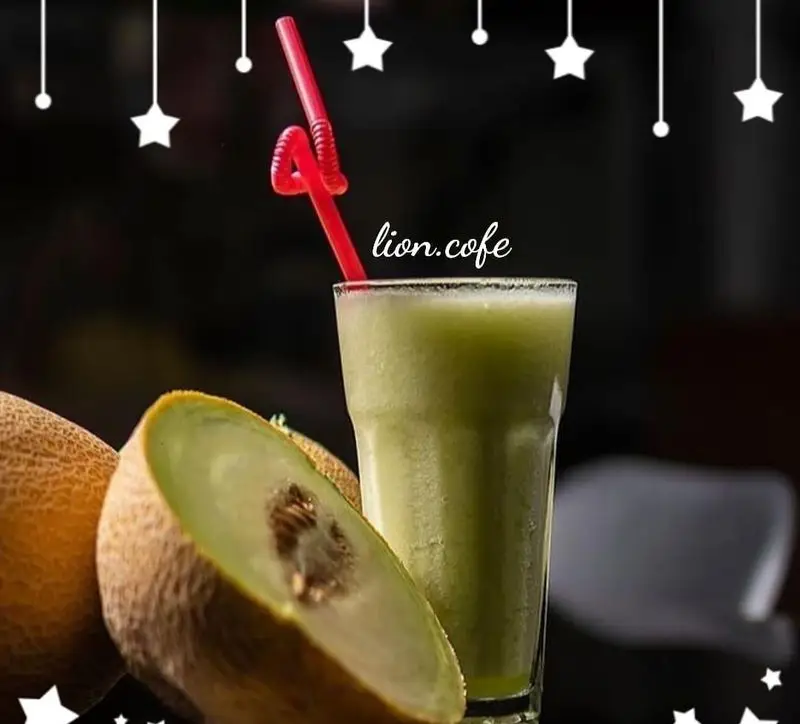 یک لیوان بزرگ آب طالبی تازه و خنک با نی قرمز رنگ، در کنار برش‌های میوه طالبی شیرین. نوشیدنی لذیذ و انرژی‌بخش از لیون کافه.