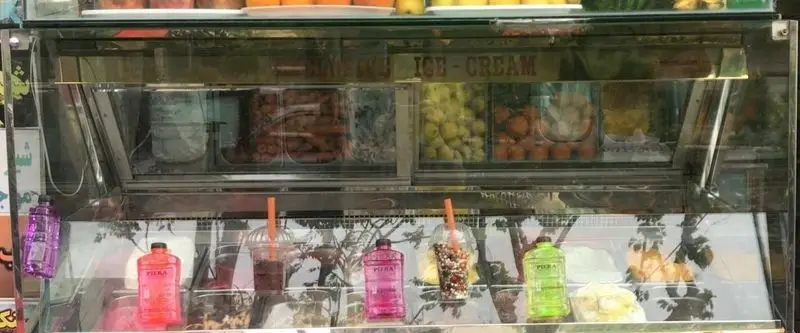 ویترین پر از میوه تازه، اسموتی و بستنی‌های متنوع در آبمیوه بستنی دلتا، مکانی عالی برای لذت.