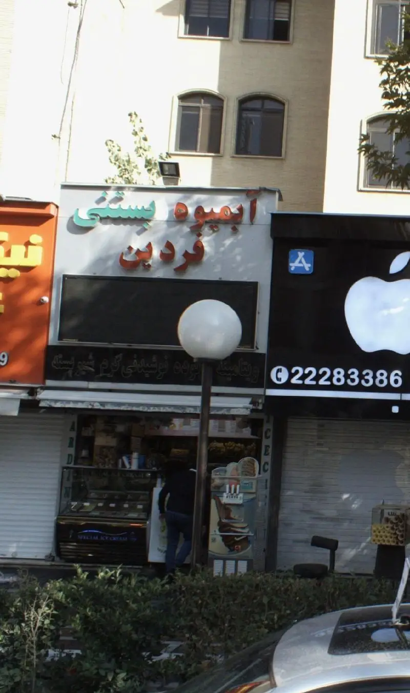 نمای بیرونی فروشگاه آبمیوه و بستنی فردین در خیابان، با تابلوی روشن کسب و کار، ویترین بستنی و ورودی مغازه.