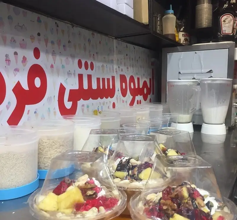 نمایی از دسرها و میوه بستنی‌های تازه و طبیعی آبمیوه فردین، با تاپینگ‌های متنوع و مغذی، آماده برای سرو به مشتریان.