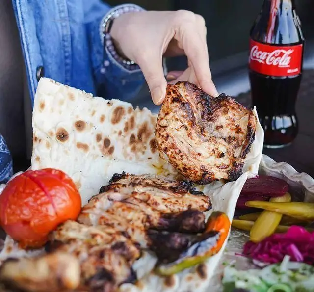 تصویری جذاب از کباب مرغ لذیذ رستوران شالِت با نان داغ، گوجه کبابی و مخلفات تازه همراه نوشابه. یک تجربه غذایی اصیل و دلنشین.