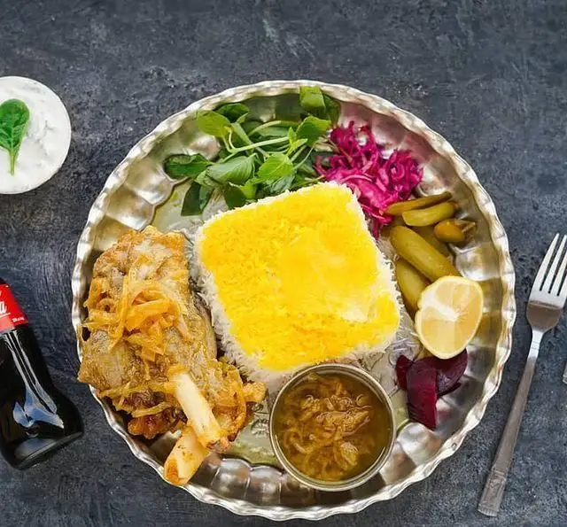 چلو ماهیچه لذیذ رستوران شالِت با برنج زعفرانی، سبزی تازه، خیارشور و ترشی. تجربه غذای سنتی ایرانی با کیفیت عالی.