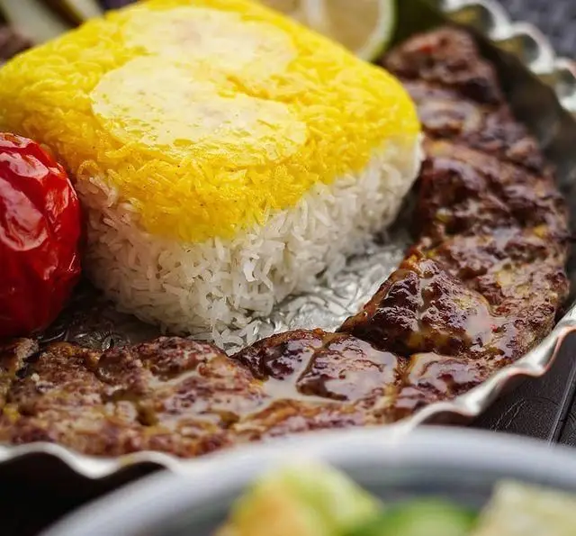 چلوکباب کوبیده زعفرانی خوش طعم رستوران شالِت با برنج اعلا، گوجه کبابی و لیمو، بهترین غذای اصیل ایرانی.