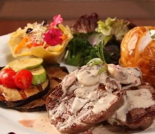 بشقاب غذای لوکس کافه هوکاجی: استیک با سس قارچ، سبزیجات گریل، سالاد رنگارنگ و دورچین زیبا. یک تجربه غذایی بی‌نظیر.