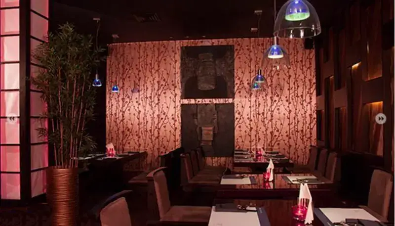 فضای داخلی لوکس و آرامش‌بخش رستوران کنزو با دکوراسیون الهام گرفته از آسیا، میز و صندلی‌های شیک و نورپردازی خاص و دلنشین.