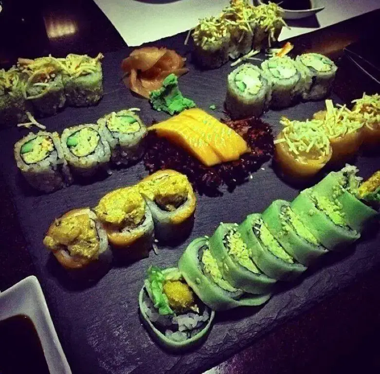 سوشی‌های لذیذ و متنوع رستوران کنزو: بشقابی پر از ماکی، اوراماکی و رول‌های ویژه با رنگ‌های جذاب و تزیینات منحصر به فرد.