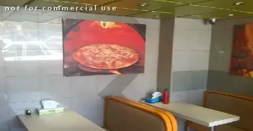 نمایی از فضای داخلی رستوران والک پیتزا، شامل میز و صندلی‌های راحتی، تصاویری جذاب از پیتزای داغ تنوری و محیطی دلپذیر.