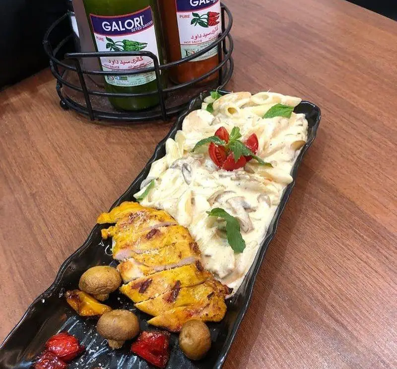 پاستا خامه‌ای با مرغ گریل، قارچ تازه و سبزیجات رنگارنگ؛ یک غذای لذیذ و پرطرفدار از منوی پیتزا مسعود.