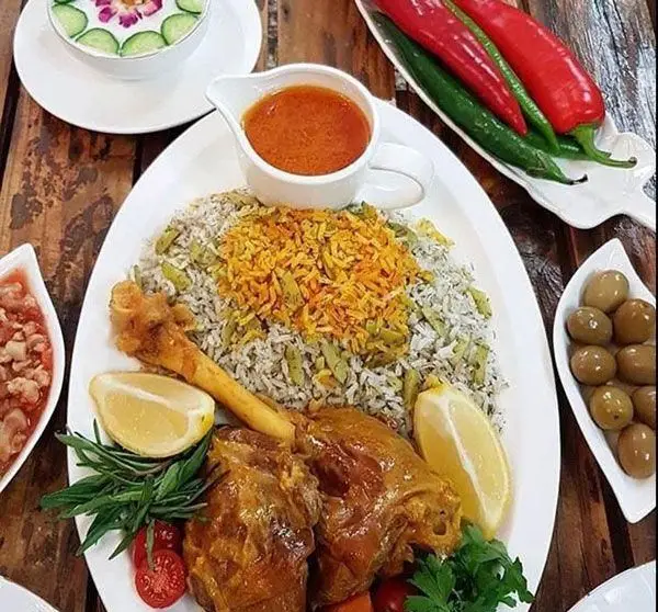 غذای لذیذ باقالی پلو با گوشت در رستوران و کترینگ مانی. شامل ماست و خیار و زیتون. بهترین غذای ایرانی سنتی با کیفیت بالا و ظاهری زیبا.