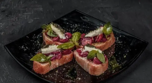 بروشتاهای تازه و خوشمزه رویال تراس، پیش غذایی عالی با نان تست، گوجه فرنگی، پنیر و ریحان تازه در فودکورت شیک ما.