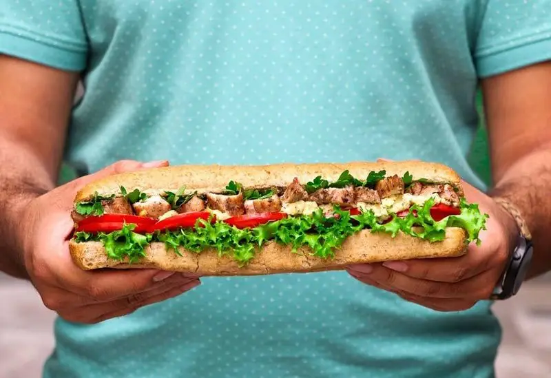 ساندویچ بزرگ و خوشمزه مرغ فست فود شیلا با کاهو تازه، گوجه فرنگی و سس مخصوص، انتخابی عالی برای یک وعده غذایی لذیذ.