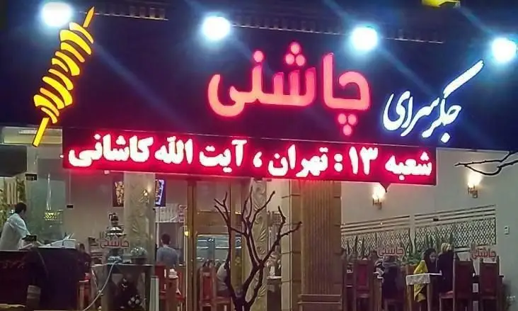 نمای بیرونی رستوران کبابی و جگرسرای چاشنی، شعبه ۱۳ تهران در شب. این مکان در خیابان آیت الله کاشانی واقع شده و انواع کباب را ارائه می‌دهد.