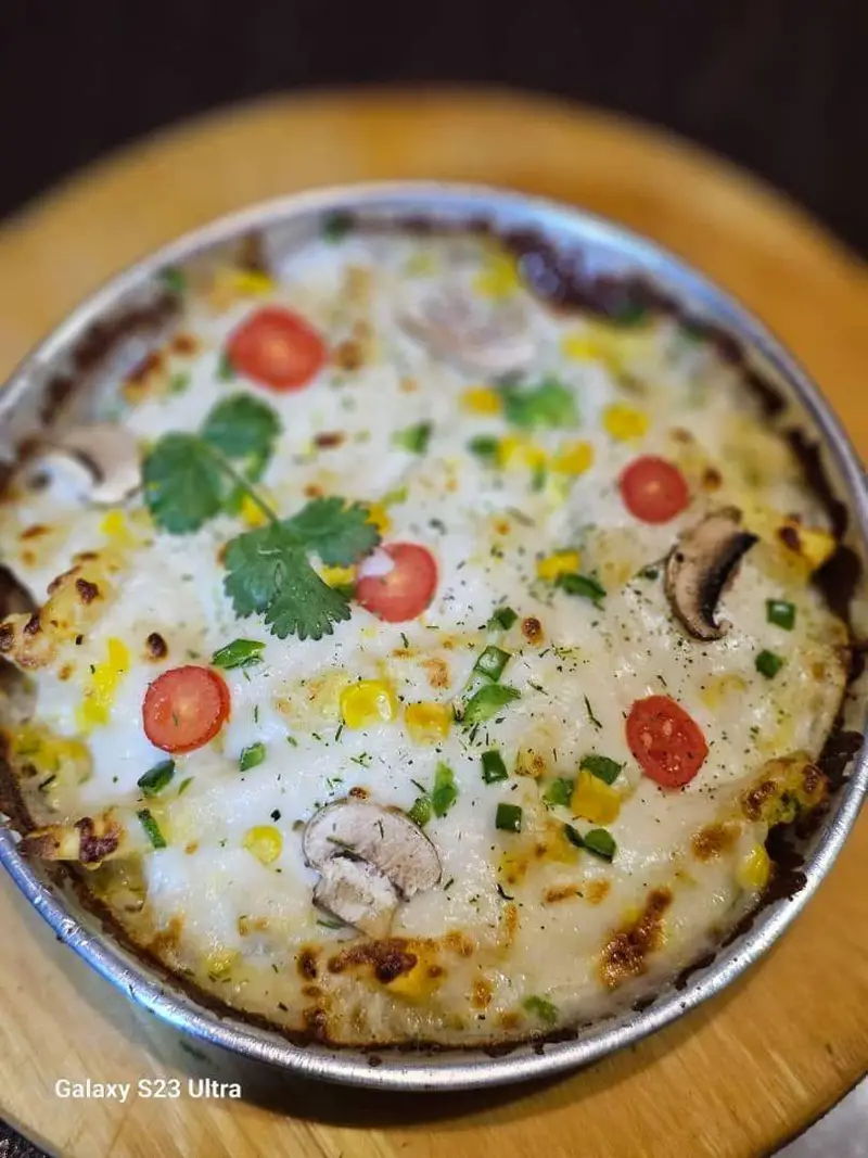 غذای پنیری ویژه کافه رستوران عجمان: پیتزا یا لازانیا با رویه پنیر ذوب شده، قارچ تازه، ذرت، گوجه و فلفل سبز. طعم بی‌نظیر.