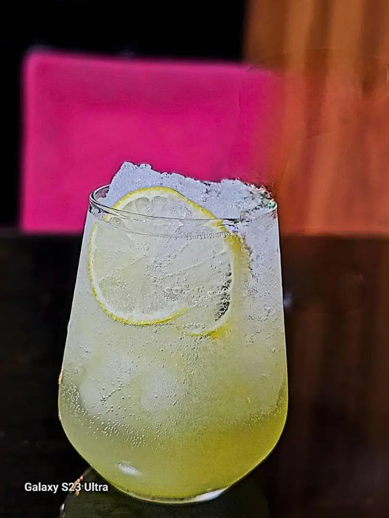 لیوانی پر از لیموناد گازدار خنک با یخ و لیمو، نوشیدنی با طراوت و لذت بخش کافه رستوران عجمان برای تابستان.