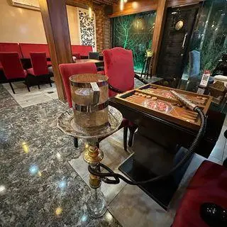 محیط داخلی کافه رستوران عجمان، بهترین انتخاب برای دورهمی با قلیان و منوی متنوع. دکوراسیون مدرن و فضای دلنشین و راحت.