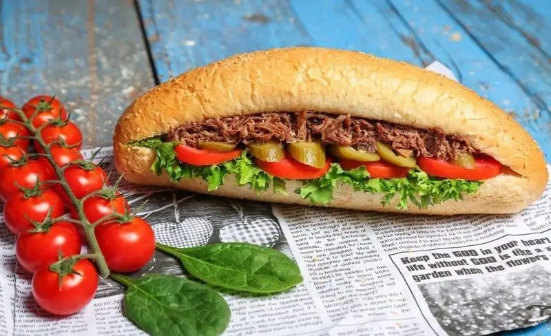 ساندویچ گوشت زغالی (رست بیف) با سبزیجات تازه و نان کنجدی در برگر زغالی قیطریه تهران.