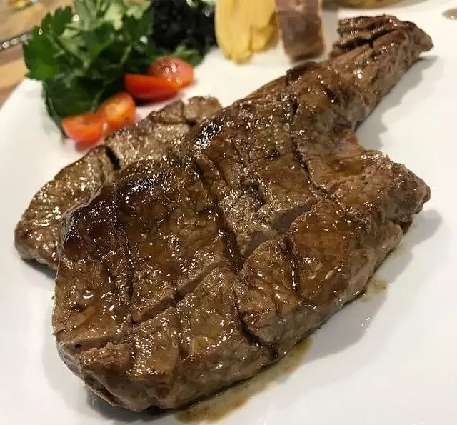 استیک گریل شده آبدار با دورچین سبزیجات تازه و گوجه گیلاسی در کافه رستوران مکث، تجربه‌ای لذیذ و به یاد ماندنی.