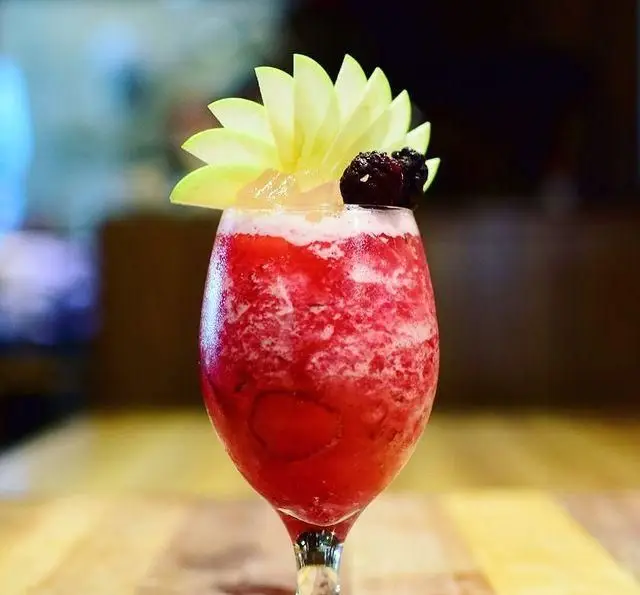 نوشیدنی خنک و میوه‌ای کافه رستوران مکث با طعم دلپذیر سیب و توت، تزئین شده زیبا برای لحظاتی گوارا و به یاد ماندنی.