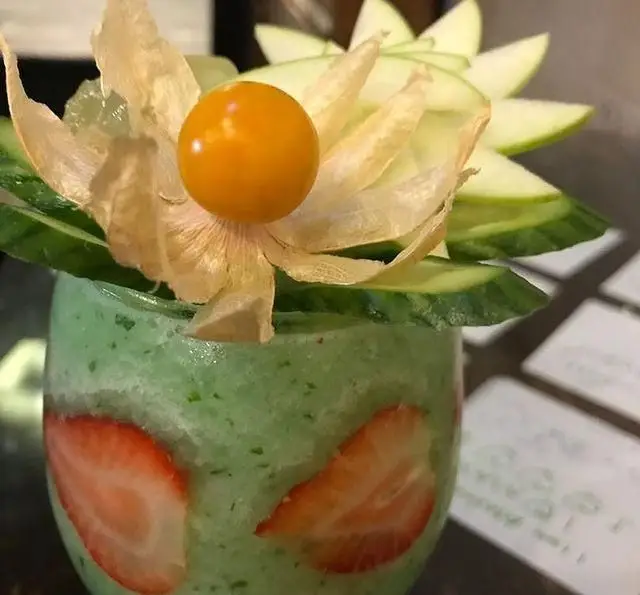 تصویری جذاب از اسموتی سبز میوه‌ای کافه رستوران مکث با توت فرنگی، خیار، سیب سبز و فیسالیس. نوشیدنی خنک و گوارا.