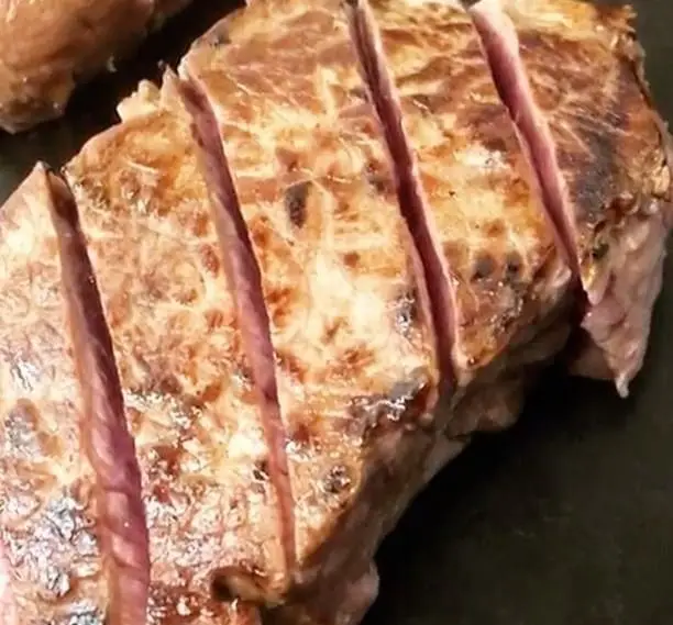 استیک گریل شده آب‌دار و برش‌خورده با پخت مدیوم ریر، آماده سرو برای میهمانان عزیز در کافه رستوران مکث.