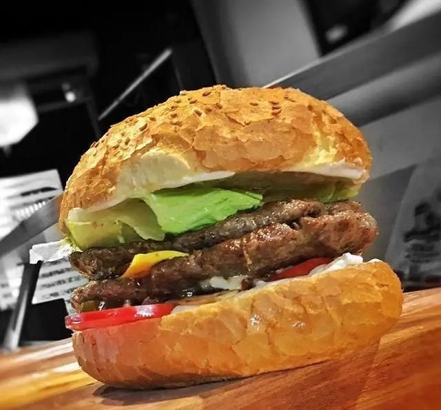 یک همبرگر دوبل آبدار و لذیذ از کافه رستوران مکث، شامل دو لایه گوشت تازه، پنیر چدار، کاهو، گوجه فرنگی، خیارشور و سس مخصوص.