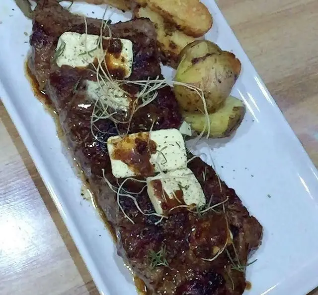 یک بشقاب استیک آبدار و لذیذ با کره سبزیجات و سیب‌زمینی تنوری در کافه رستوران مکث. غذای اصلی خوشمزه و محبوب.