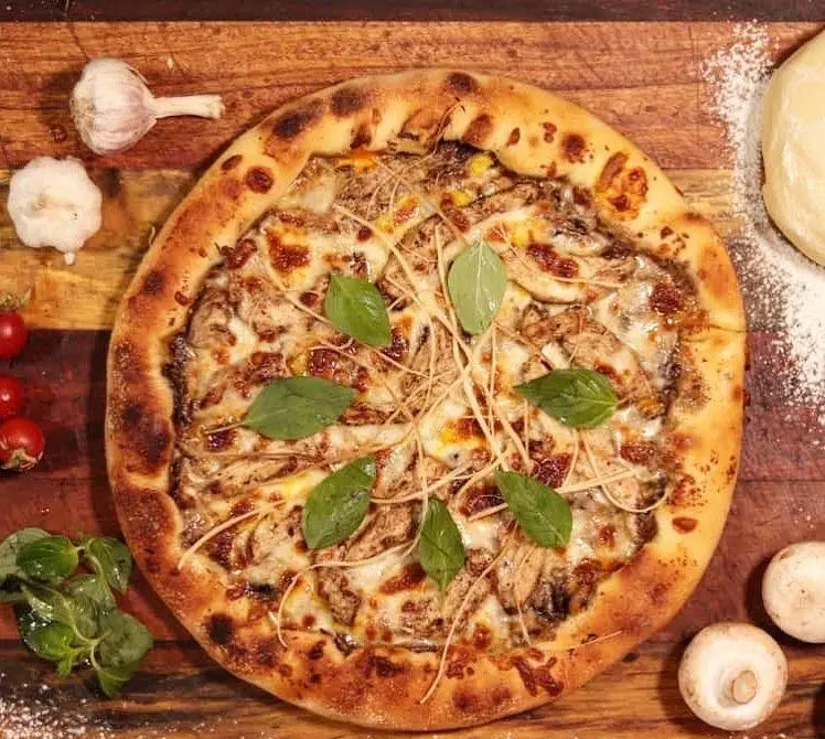 پیتزا مرغ و قارچ کافه رستوران مکث با پنیر فراوان، ریحان و خمیر دست‌ساز. بهترین انتخاب برای یک ناهار یا شام لذیذ.