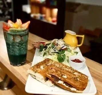 صبحانه یا ناهار دلپذیر در کافه رستوران مکث. شامل ساندویچ گریل، سالاد تازه، نوشیدنی اسموتی میوه ای و فضای آرامش بخش.