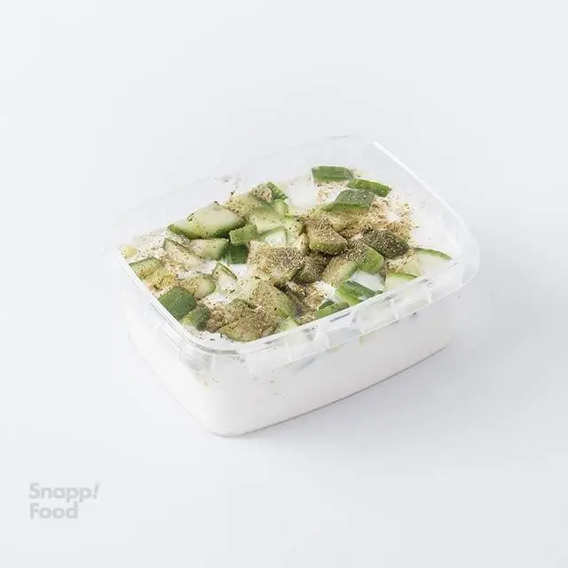 ماست و خیار خنک و تازه پرو کالری سعادت آباد، با خیار خرد شده و نعناع خشک، پیش غذایی سالم و رژیمی در ظرف یکبار مصرف شفاف.