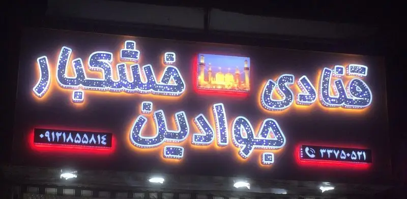 تابلو نورانی و جذاب قنادی جوادین و خشکبار با حروف برجسته فارسی، شامل نام کسب و کار، شماره‌های تماس و تصویر حرم امام رضا