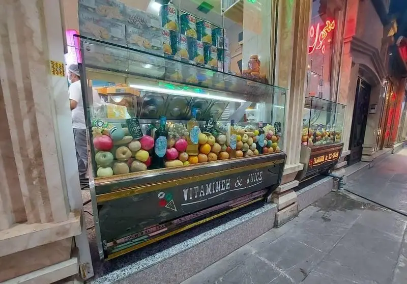 ویترین جذاب دکه آبمیوه و ویتامینه بستنی مسعود، پر از میوه‌های تازه و رنگارنگ آماده برای تهیه نوشیدنی‌های طبیعی و سالم.