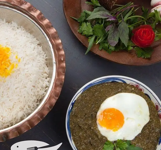 غذای اصیل و کامل ایرانی در رستوران ماهی سفید: پلو زعفرانی در دیگ مسی، خورش سبزی با تخم مرغ نیمرو و سبزی خوردن تازه.