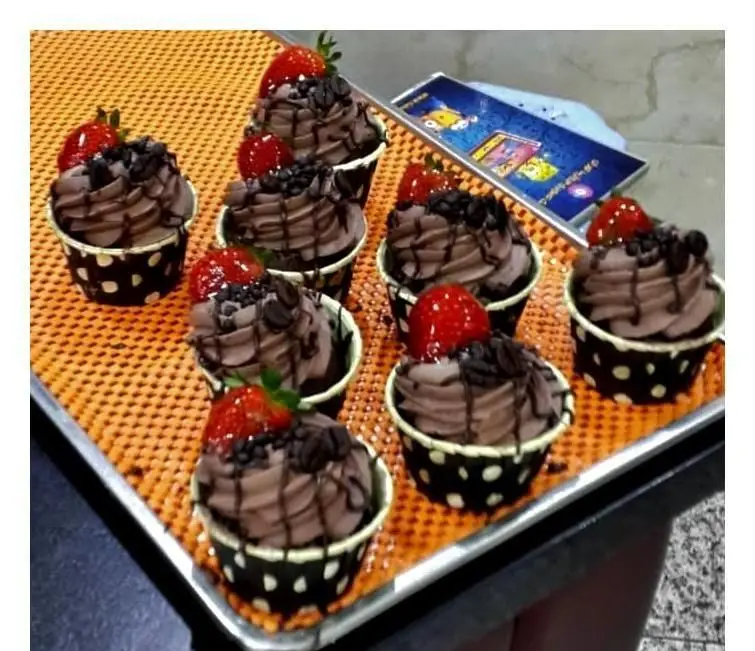 کاپ کیک‌های شکلاتی خوشمزه با روکش خامه شکلاتی، سس شکلات، تکه‌های کاکائو و توت فرنگی تازه از شیرینی سرای پــدر. سفارش آنلاین دسر.