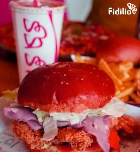 برگر مرغ سوخاری قرمز و خوشمزه جیکی بیف با نان کنجدی، کاهو و سیب‌زمینی سرخ‌کرده. یک غذای فست فود هیجان‌انگیز.