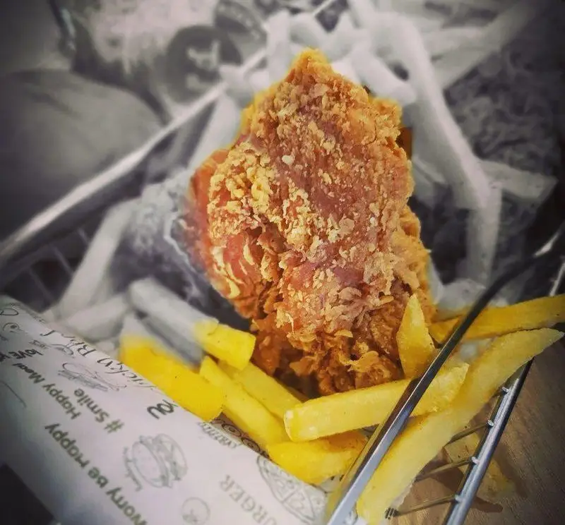 مرغ سوخاری ترد و طلایی با سیب زمینی سرخ کرده خوش‌طعم در سبد فلزی جیکی بیف؛ بهترین فست فود برای یک وعده غذایی دلپذیر.