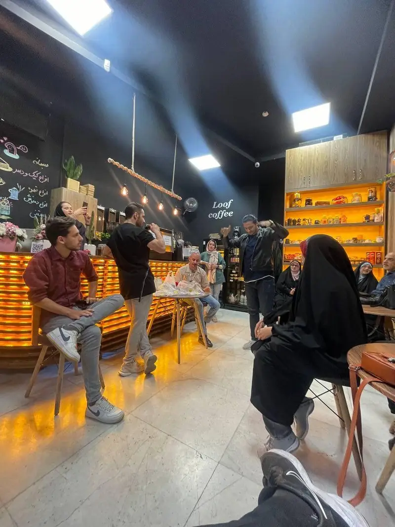 نمایی از فضای داخلی کافه لوف، با مشتریانی که در حال گپ زدن و لذت بردن از قهوه و دسرهای خوشمزه هستند. محیطی دلنشین و پویا.