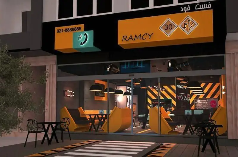 نمای بیرونی رستوران فست فود RAMCY با دکوراسیون داخلی مدرن، صندلی‌های زرد، دیوار راه راه، تابلوی RAMCY، شماره تلفن و میزهای بیرونی.