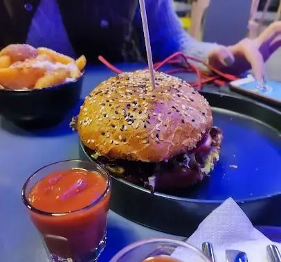 همبرگر بزرگ و آبدار با نان کنجدی، همراه سیب زمینی سرخ کرده و سس کچاپ در کافه رستوران الک دولک. انتخابی عالی برای یک وعده غذایی لذیذ.