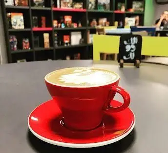 یک فنجان قهوه لاته با طرح هنری دلپذیر در کافه رستوران الک دولک، فضایی آرام و ایده‌آل برای تجربه نوشیدنی‌های گرم.