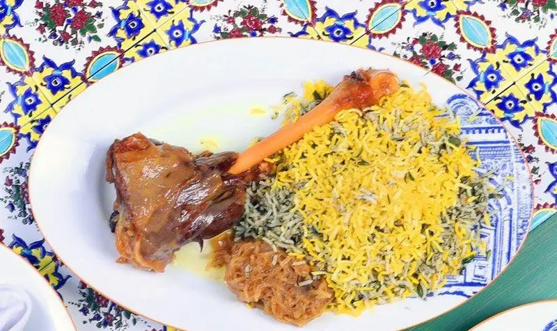 تصویری از غذای سنتی و لذیذ ایرانی: ماهیچه پخته شده در کنار پلو زعفرانی و سبزی پلو، سرو شده در کافه رستوران وکیل التجار.