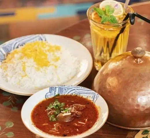 غذای اصیل ایرانی در کافه رستوران وکیل التجار شامل برنج زعفرانی، خورشت سنتی و نوشیدنی خنک. تجربه‌ای دلپذیر از طعم‌های بی‌نظیر.