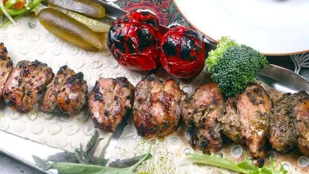 کباب جوجه آبدار و خوشمزه با گوجه کبابی و خیارشور در کافه رستوران وکیل التجار شیراز. غذای سنتی و لذیذ ایرانی.