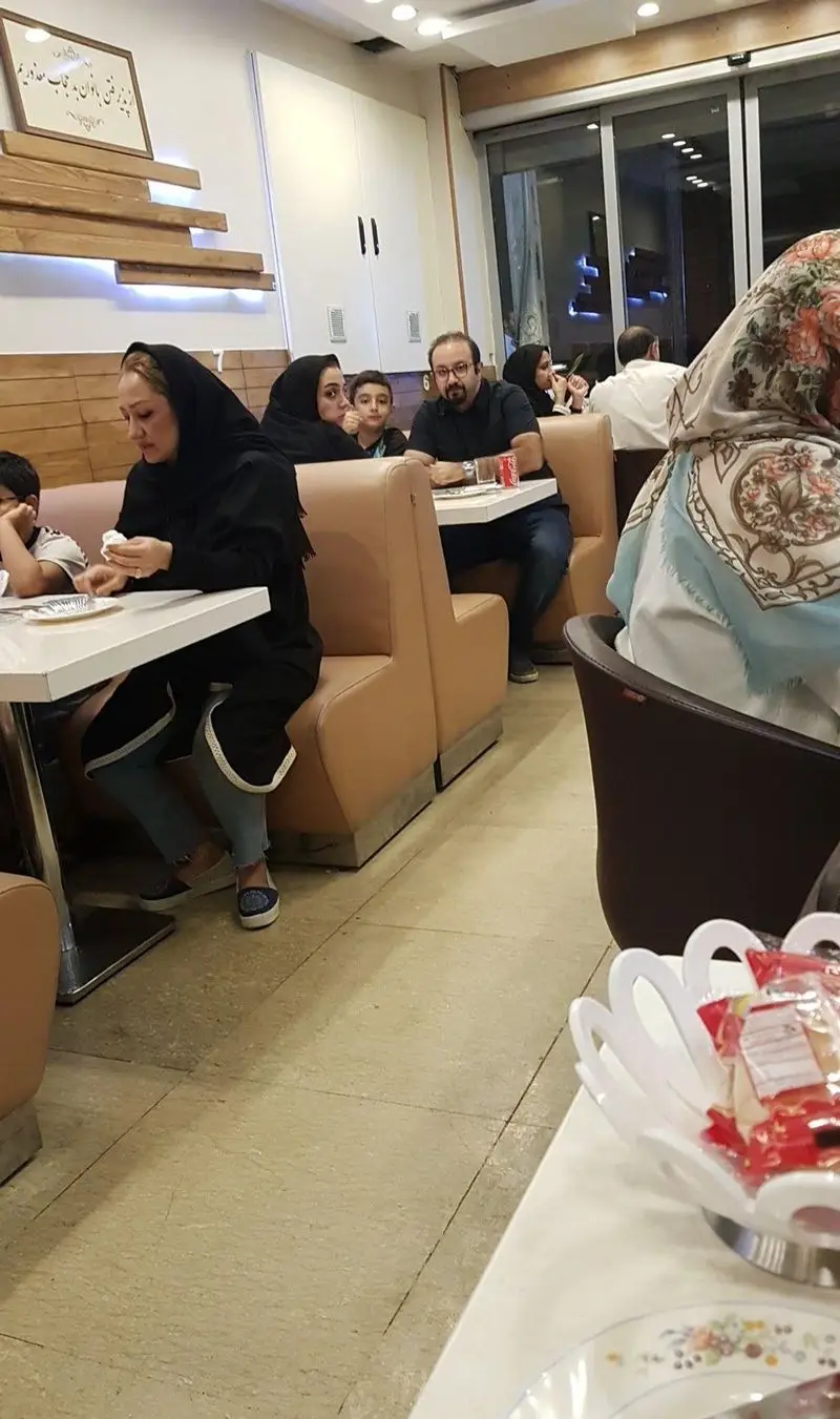 مشتریان و خانواده‌ها در حال لذت بردن از فضای دلپذیر و صرف غذا در رستوران مرغ سوخاری دی، با دکوراسیونی مدرن.