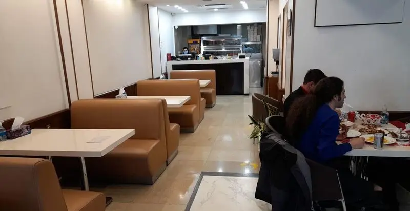 فضای داخلی دنج و مدرن رستوران مرغ سوخاری دی با میزهای تمیز و صندلی‌های راحتی قهوه‌ای، مناسب برای صرف غذا و دورهمی.