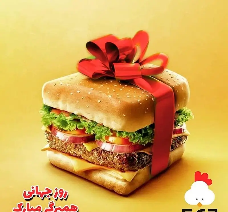 همبرگر مکعبی شکل تزئین شده با ربان قرمز به عنوان هدیه، به مناسبت روز جهانی همبرگر توسط مرغ سوخاری دی. طعم خاص و ظاهری جذاب.