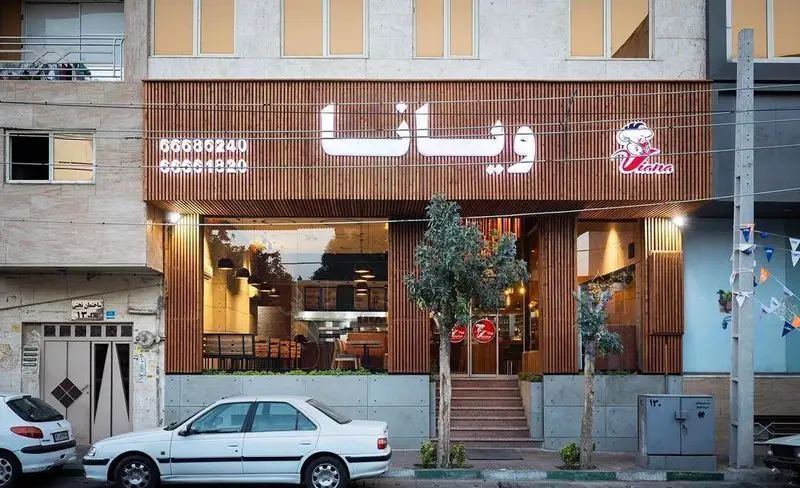 تصویر نمای بیرونی رستوران ویانا با طراحی مدرن، نمای چوبی، ورودی شیشه‌ای و شماره تلفن‌های ۶۶۶۸۶۲۴۰ و ۶۶۶۸۴۸۲۰.